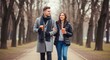 © PixelPulse Creative - Young couple walking in a park in autumn, holding coffee cups and smiling at each other, wearing winter coats and scarves