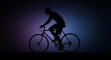 Silhouette of cyclist riding bicycle against purple light background.