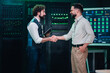 © Zamrznuti tonovi - It professionals shaking hands in server room, symbolizing successful partnership, collaboration, and data center agreement