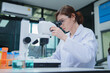 © ijeab - Female Scientist Conducting Research with Microscope in Laboratory