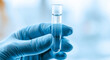 © Justin Eaton - Scientist Hand in Blue Glove Holding Test Tube with Liquid
