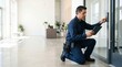 © Oleg - Professional Technician Kneeling at a Glass Door Keypad While Holding a Tablet in a Bright Modern Lobby. Access control installation and security system maintenance in a contemporary commercial