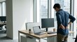 © Irvan - Man stretching lower back pain at modern office standing desk