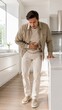 © Flash memory - Man suffering from stomach ache in modern kitchen. Caucasian person touching abdomen due to abdominal pain or digestion problem. Health issue, medical symptom and food poisoning concept.