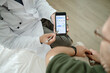© Seventyfour - Senior patient visiting doctor in clinic, reviewing glucose monitoring app on smartphone during consultation. Supporting diabetes care, telehealth promotion, patient education marketing