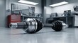 © Pixels Stock - Automotive CV joint or driveshaft component on workshop floor with tools and equipment in background demonstrating industrial mechanical engineering and auto repair.