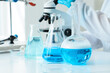 © Pixel-Shot - Laboratory research with blue liquid in glassware, scientific experimentation, and medical development