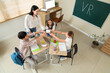 © Pixel-Shot - Female teacher and pupils with VR glasses in classroom, top view