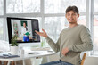 © Pixel-Shot - Male student studying with online teacher at table in room