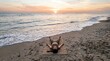 © SAFIICLON - A Woman Practicing Savasana Corpse Pose on a Yoga Mat at the Beach During a Peaceful Sunrise Over the Ocean
