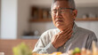 © KotBaton - Middle-aged man experiencing choking during a meal at home, illustrating a medical emergency, first aid awareness, airway obstruction, health risks, and emergency response concepts.