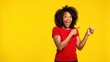 © rahwik - joyful surprised young woman pointing in vibrant yellow studio background perfect for advertisement copy placement