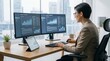 © Taufik - Business leader reviewing predictive analytics on dual monitors in a modern office