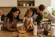 © La Famiglia - Family making cake together in modern kitchen