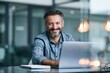 © Аrtranq - Smiling man working on laptop at modern office desk