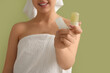 © Pixel-Shot - Happy smiling young woman in towel with crystal deodorants on green background, closeup