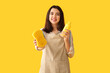 © Pixel-Shot - Young woman with sponge and bottle of detergent on yellow background