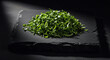 © MstManoara - Fresh green herbs prepared in a chiffonade style served on a rustic black slate board for professional culinary presentation and gourmet food styling photography