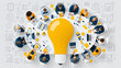 © pattozher - Business Brainstorming Session: A team of diverse professionals sits around a large table, collaborating on ideas symbolized by a giant glowing lightbulb.
