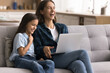 © fizkes - Laughing young mother and cute little 10s daughter having fun, giggling, watching cartoons or family movie series, using online educational platform, enjoy carefree weekend leisure using modern laptop
