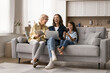 © fizkes - Intergenerational women family spend free time on internet, laughing while sitting on sofa with diverse modern wireless devices, enjoy on-line content, watching share funny videos. Technologies usage