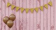 © Muhammad - Brown balloons tied together with yellow pennant banner on pink wooden planks