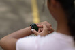 © itchaznong - Close up of woman checking smartwatch on wrist for fitness tracking outdoors