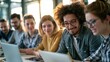 © Selvi - Diverse group of young adults collaborating together with laptops in a bright workspace