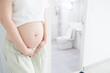© Orawan - Incontinence and frequent urination during pregnancy. Pregnant woman need to pee standing by toilet in bathroom.