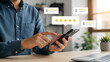 © Arslan - Closeup of a man using a smartphone to give a fivestar rating, representing customer satisfaction, service feedback, and digital review concepts