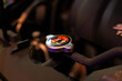 © Terence - Close-up of a car radiator pressure cap with yellow warning labels, connected to a coolant reservoir tank inside a modern vehicle's engine bay