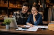 © Olena Apetroaiei - Partnership thrives as happy store owners examine sales reports with a smile