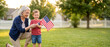 © Kristelinmind - Grandmother and grandson holding an American flag in the backyard. Happy generations celebrating Independence Day together. Patriotic holiday concept with family unity in the outdoors.