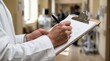 © l1gend - Medical professional's hands writing on a clipboard for patient documentation concept