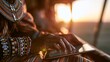 © Justlight - Hands wearing colorful cultural bead bracelets interact with a tablet on a sundrenched veranda warm soft lens flare bathing the scene and a rich red soil vista softly out of focus.