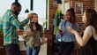 © DC Studio - Group of friends dancing at apartment party, having fun together, moving their feet on rhythm. BIPOC people doing energetic dance moves on upbeat songs in brick wall living room