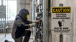 © FrameLab - Electrician in Protective Arc Flash Suit Performing High Voltage Transformer Maintenance at Industrial Power Substation
