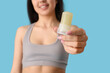 © Pixel-Shot - Beautiful young woman with crystal deodorant on blue background, closeup