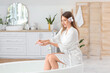 © Pixel-Shot - Beautiful woman pouring bath product into bathtub at home
