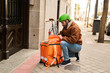 © Oscar - Courier opening delivery bag at residential door