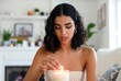 © BloomPix - Young Woman Lighting Candle in Cozy Living Room at Home