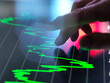 © Connect Images - Hand interacts with financial graph on a touchscreen in a high-tech setting.