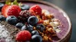 © fivan - A macro close up of a vibrant smoothie bowl topped with fresh berries, granola, and seeds with detailed texture and bright natural lighting