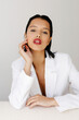 © Tania Cervian/Stocksy - Woman wearing white blazer and red lipstick