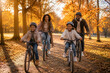 © Rufino - Golden autumn light bathes a joyful family biking