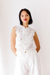 © Tania Cervian/Stocksy - Model posing wearing white lace top