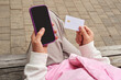 © Amor Burakova/Stocksy - Person making online payment using smartphone and credit card