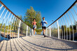 © Nunez Image SL/Stocksy - Multiethnic couple running on a bridge in a park