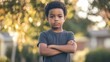 © Granger - Serious young boy with arms crossed, outdoors.