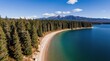 © Viktor - Aerial view of a pristine lake and forest shoreline. Clear turquoise water meets a sandy beach, with snow-capped mountains in distance. Rich pine trees form a dense border along the coast.